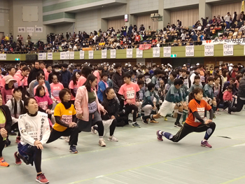 参会者と一緒に準備運動をする岡崎さんの写真
