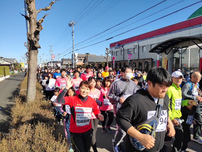 ランニングをしながら手を振る岡崎さんの写真