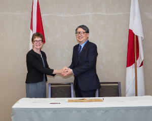 Anne Merklinger, chief executive officer of Own the Podium, and ASHIDATE Satoshi, President of JSC, shake hands after the signing ceremony.