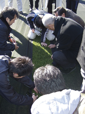 シート下の芝の状態を確認する参加者